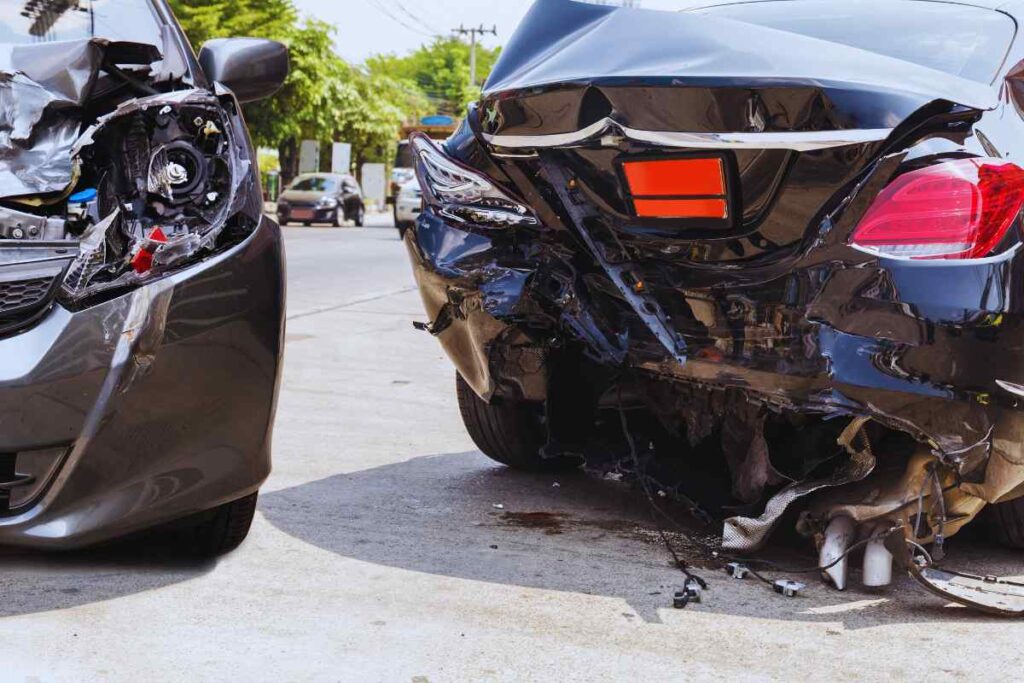 Two damaged vehicles stopped after a rear-end collision on a city street, showing significant rear and front vehicle damage relevant to fault and insurance evaluation after a rideshare crash.