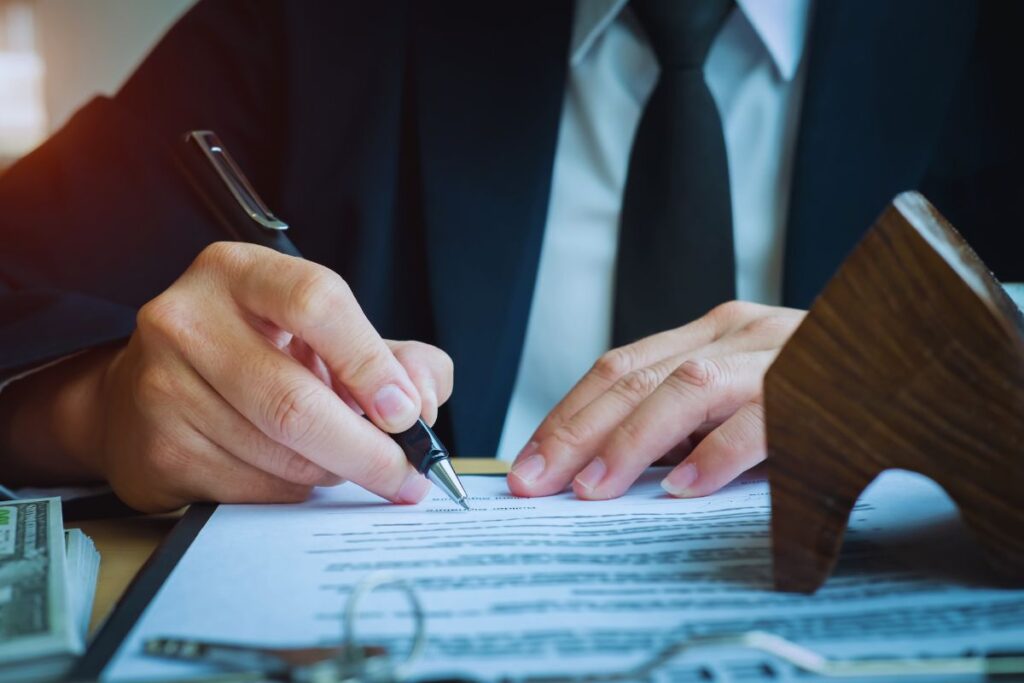 An attorney reviewing and signing legal paperwork, representing the documentation and claim decisions that follow an Uber or Lyft accident in San Diego.