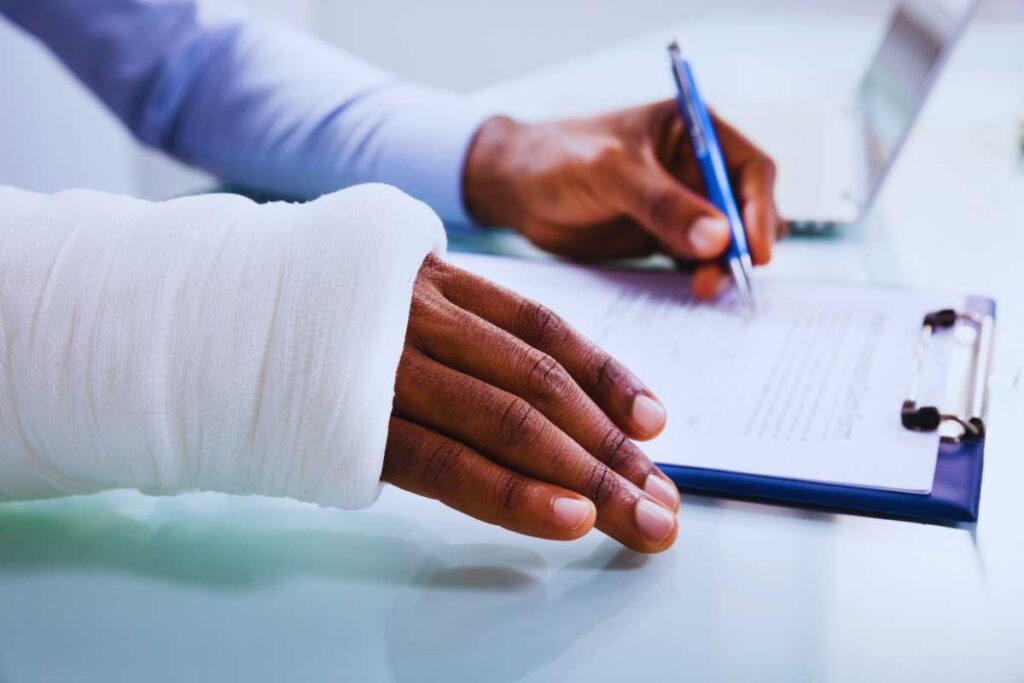 injured person with a cast signing paperwork on a clipboard, highlighting the importance of documentation in San Diego personal injury claims.