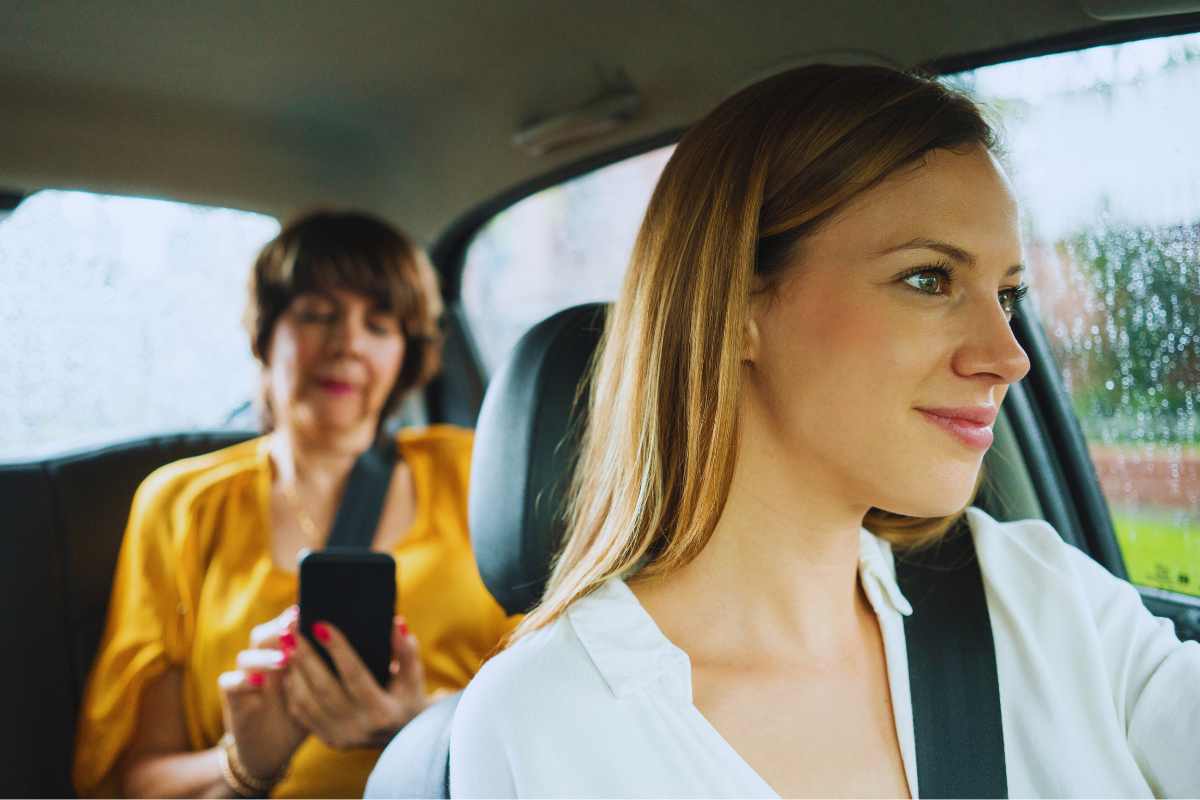 Uber driver with a passenger seated in the back of a car in San Diego, representing rideshare travel and insurance coverage considerations after an accident.